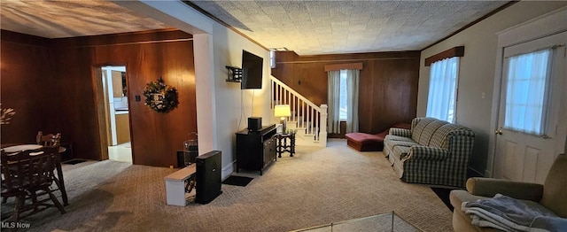 living room with wooden walls, crown molding, and carpet floors