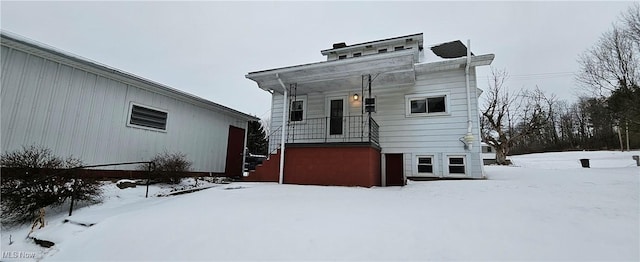 view of snow covered back of property