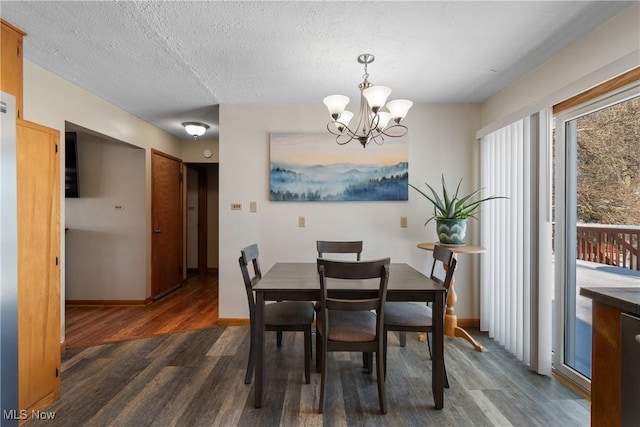 dining room with a textured ceiling, a chandelier, and dark hardwood / wood-style floors