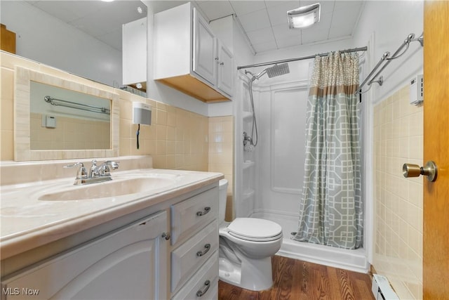 bathroom featuring walk in shower, vanity, wood-type flooring, a baseboard radiator, and toilet