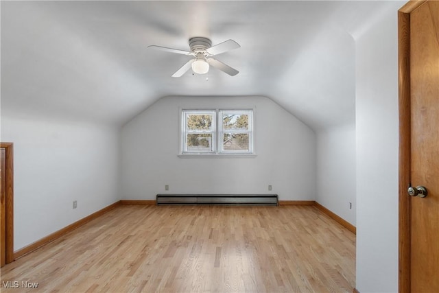 additional living space with baseboard heating, ceiling fan, vaulted ceiling, and light wood-type flooring