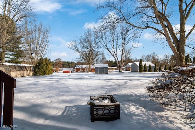 yard layered in snow featuring a shed