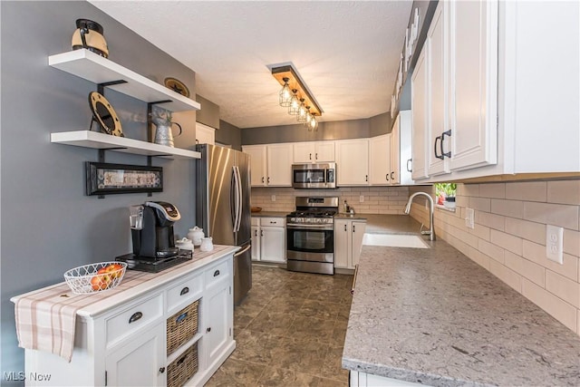 kitchen featuring white cabinets, decorative backsplash, sink, and appliances with stainless steel finishes