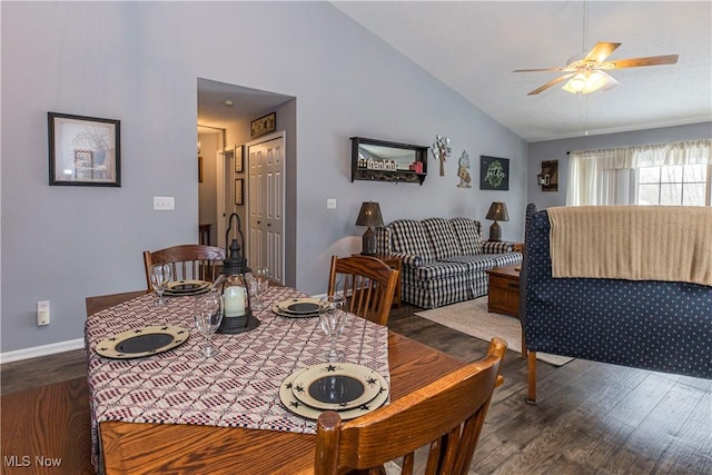 dining space featuring ceiling fan, dark wood-type flooring, and vaulted ceiling