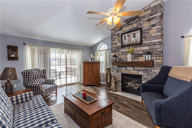 living room with hardwood / wood-style floors, ceiling fan, lofted ceiling, and a fireplace