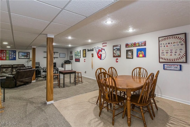 carpeted dining space featuring a paneled ceiling