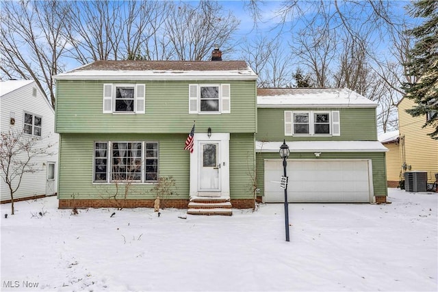 view of front of property featuring a garage and central AC