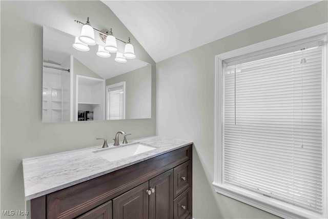 bathroom featuring a shower, vanity, and lofted ceiling