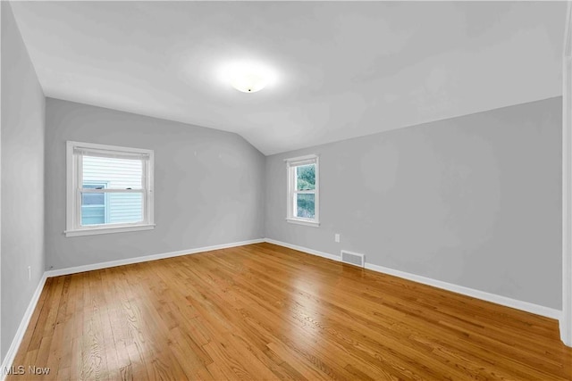 bonus room with lofted ceiling and light wood-type flooring