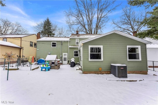 snow covered back of property featuring central air condition unit