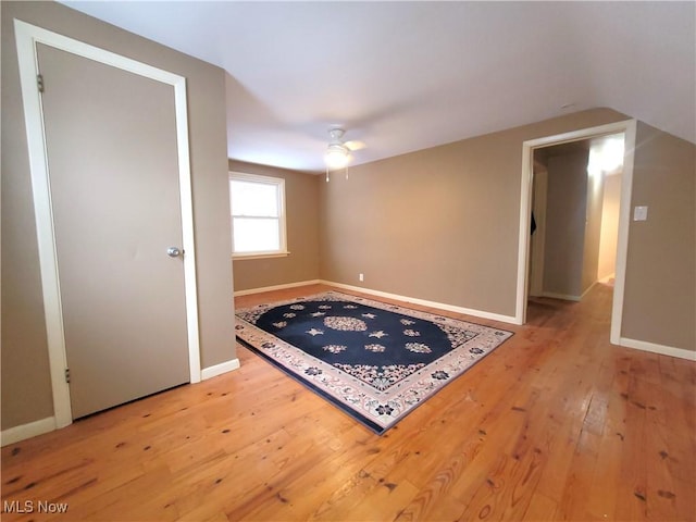 spare room featuring hardwood / wood-style floors, vaulted ceiling, and ceiling fan