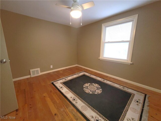 spare room with hardwood / wood-style flooring and ceiling fan