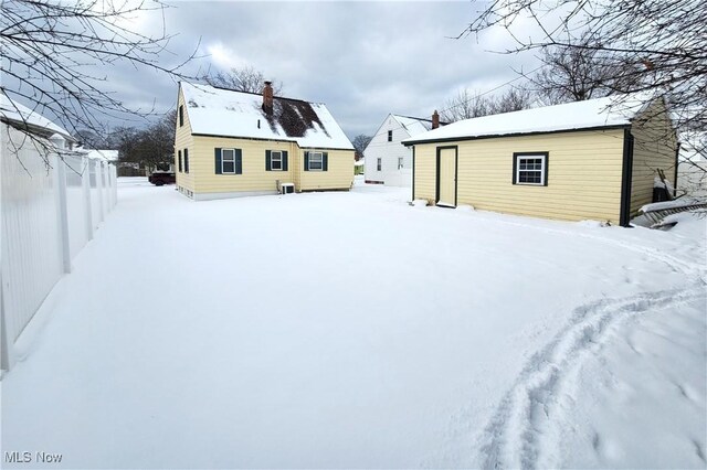 snow covered property with an outdoor structure