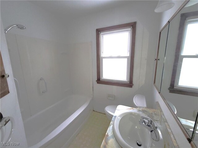 full bathroom featuring vanity, a healthy amount of sunlight, bathtub / shower combination, and toilet