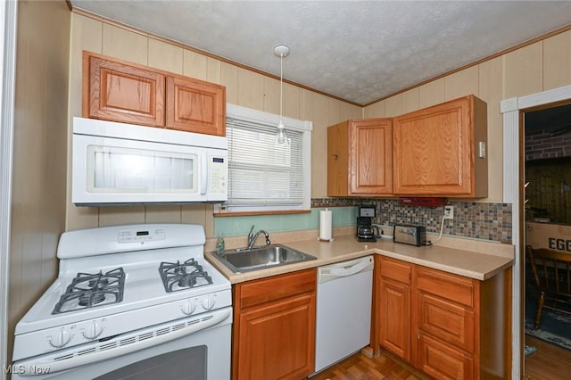 kitchen with sink, parquet flooring, pendant lighting, a textured ceiling, and white appliances