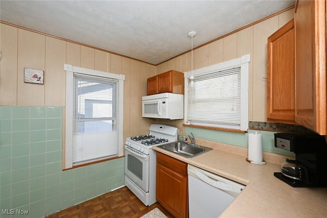 kitchen with dark parquet flooring, white appliances, a textured ceiling, sink, and pendant lighting