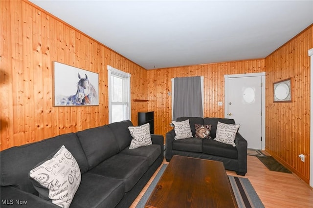 living room with light hardwood / wood-style floors and wooden walls