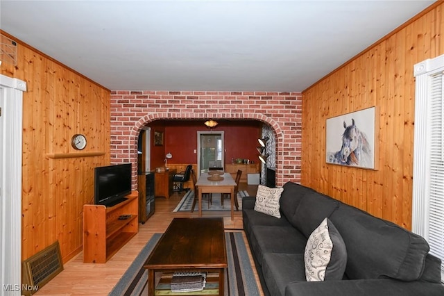 living room featuring light hardwood / wood-style flooring and brick wall