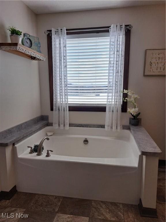 bathroom featuring a washtub and a wealth of natural light