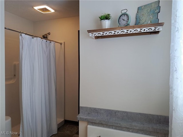 bathroom with a shower with curtain and a textured ceiling