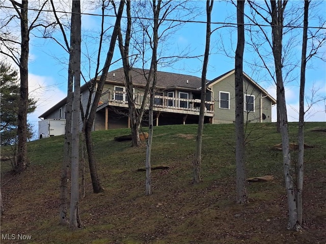 rear view of property with a lawn and a deck