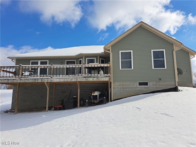 snow covered house with a deck