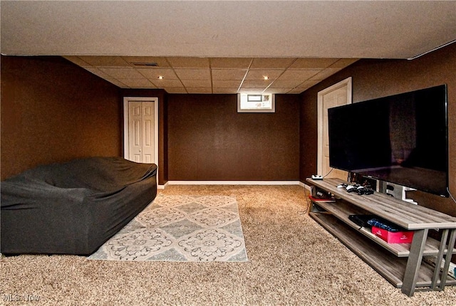 carpeted living room featuring a drop ceiling