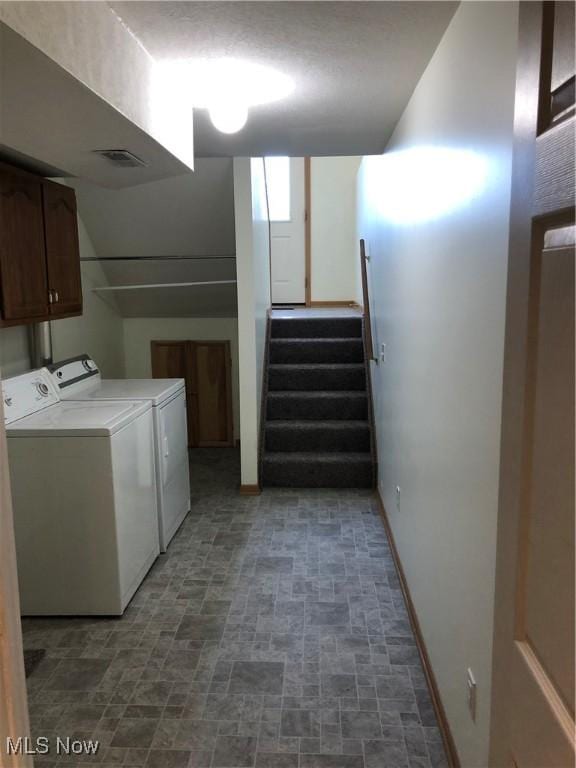 clothes washing area featuring cabinets and independent washer and dryer