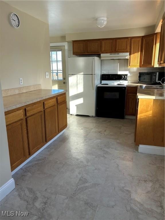 kitchen featuring decorative backsplash and white appliances