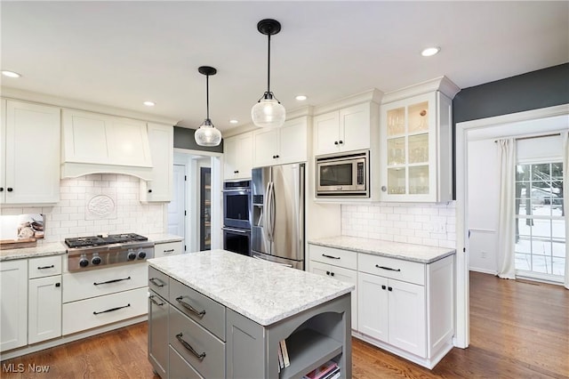 kitchen with light stone counters, white cabinets, and appliances with stainless steel finishes