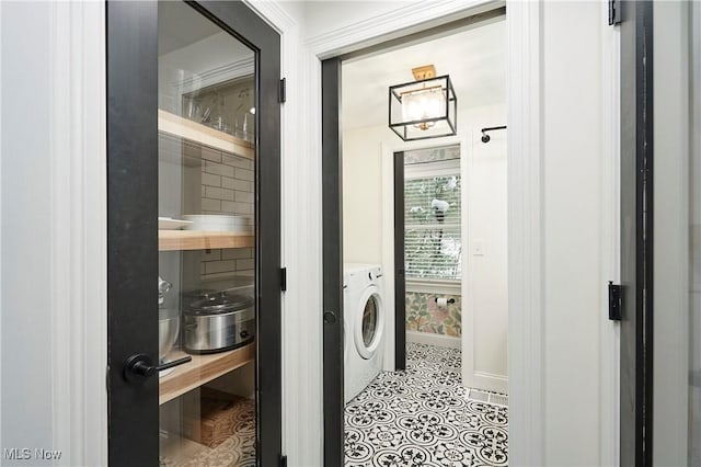 clothes washing area with light tile patterned floors and washer and dryer