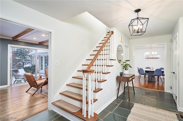 stairs with beam ceiling and an inviting chandelier