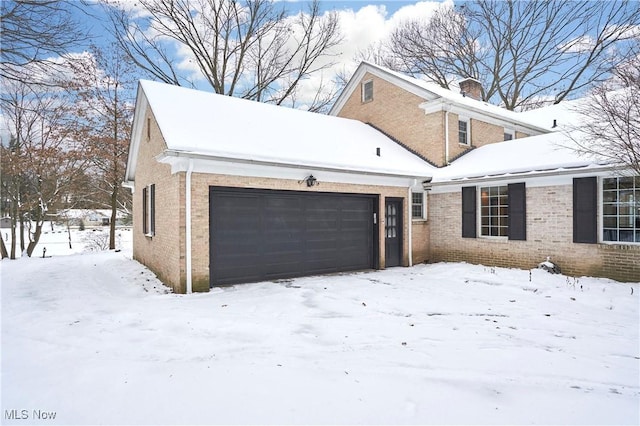 view of snowy exterior featuring a garage