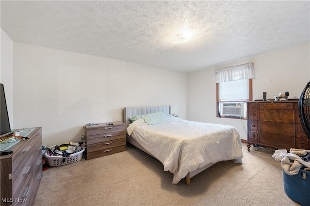 bedroom with cooling unit, light colored carpet, and a textured ceiling