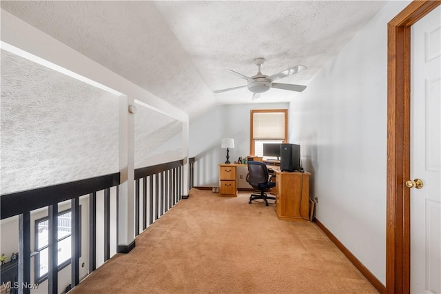 carpeted home office featuring ceiling fan, lofted ceiling, and a textured ceiling