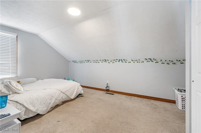 bedroom featuring light carpet and lofted ceiling