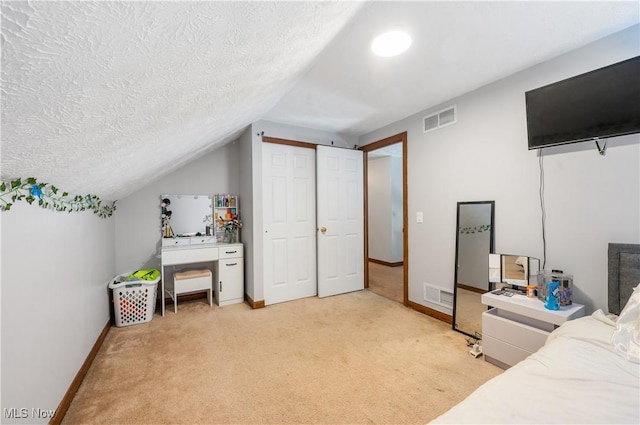 bedroom with carpet flooring, a textured ceiling, a closet, and lofted ceiling