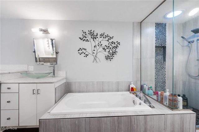 bathroom with vanity and shower with separate bathtub