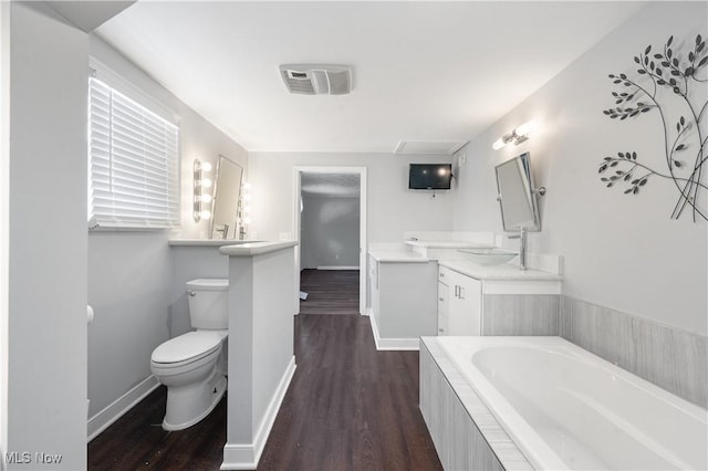 bathroom with wood-type flooring, toilet, a bathtub, and sink