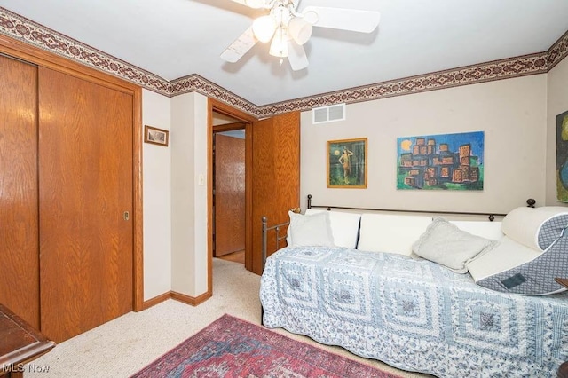 carpeted bedroom featuring a closet and ceiling fan