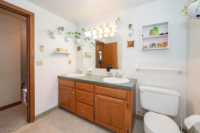 bathroom featuring tile patterned flooring, vanity, toilet, and tile walls