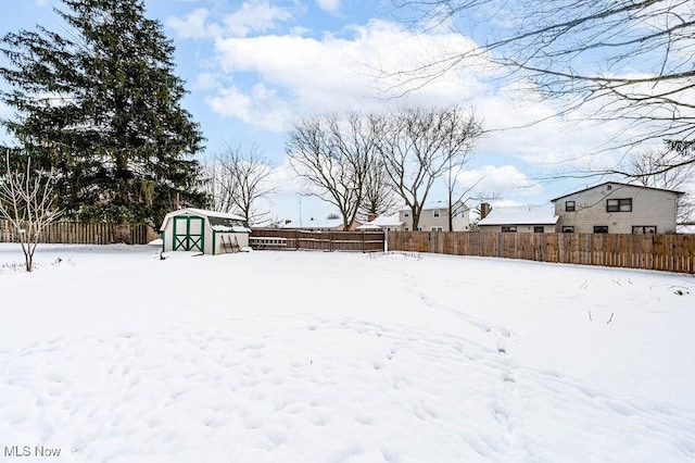 snowy yard featuring a shed