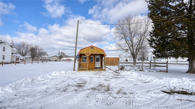 snowy yard featuring an outbuilding