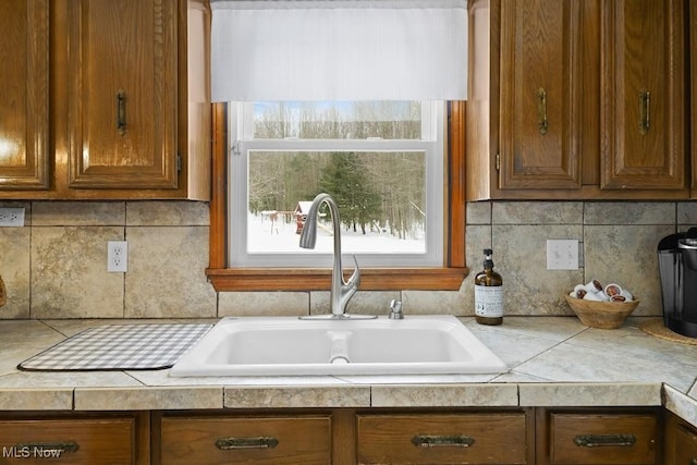 kitchen featuring backsplash, tile countertops, and sink