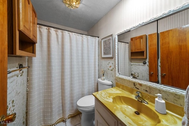 bathroom with vanity, a textured ceiling, toilet, and tile patterned flooring