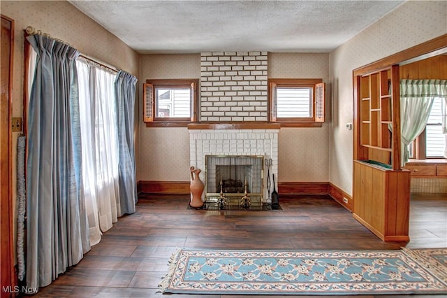 unfurnished living room featuring dark hardwood / wood-style flooring, a fireplace, and a textured ceiling