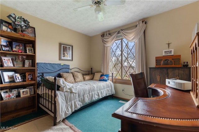 carpeted bedroom featuring ceiling fan and a textured ceiling