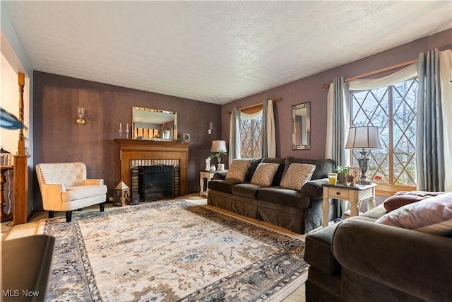 living room with a textured ceiling and a brick fireplace