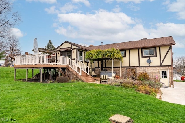 rear view of house with a lawn, a wooden deck, and a sunroom