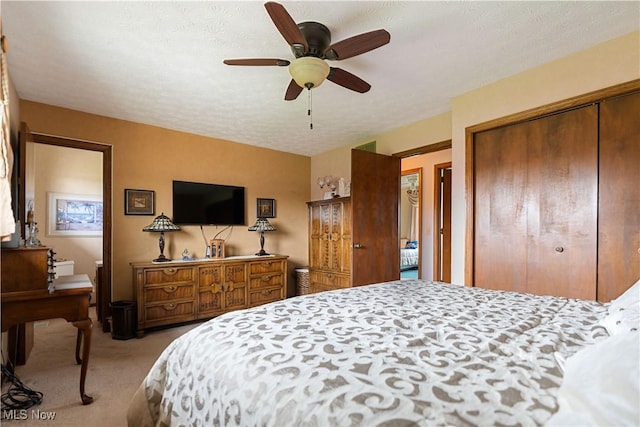 carpeted bedroom with a closet and ceiling fan